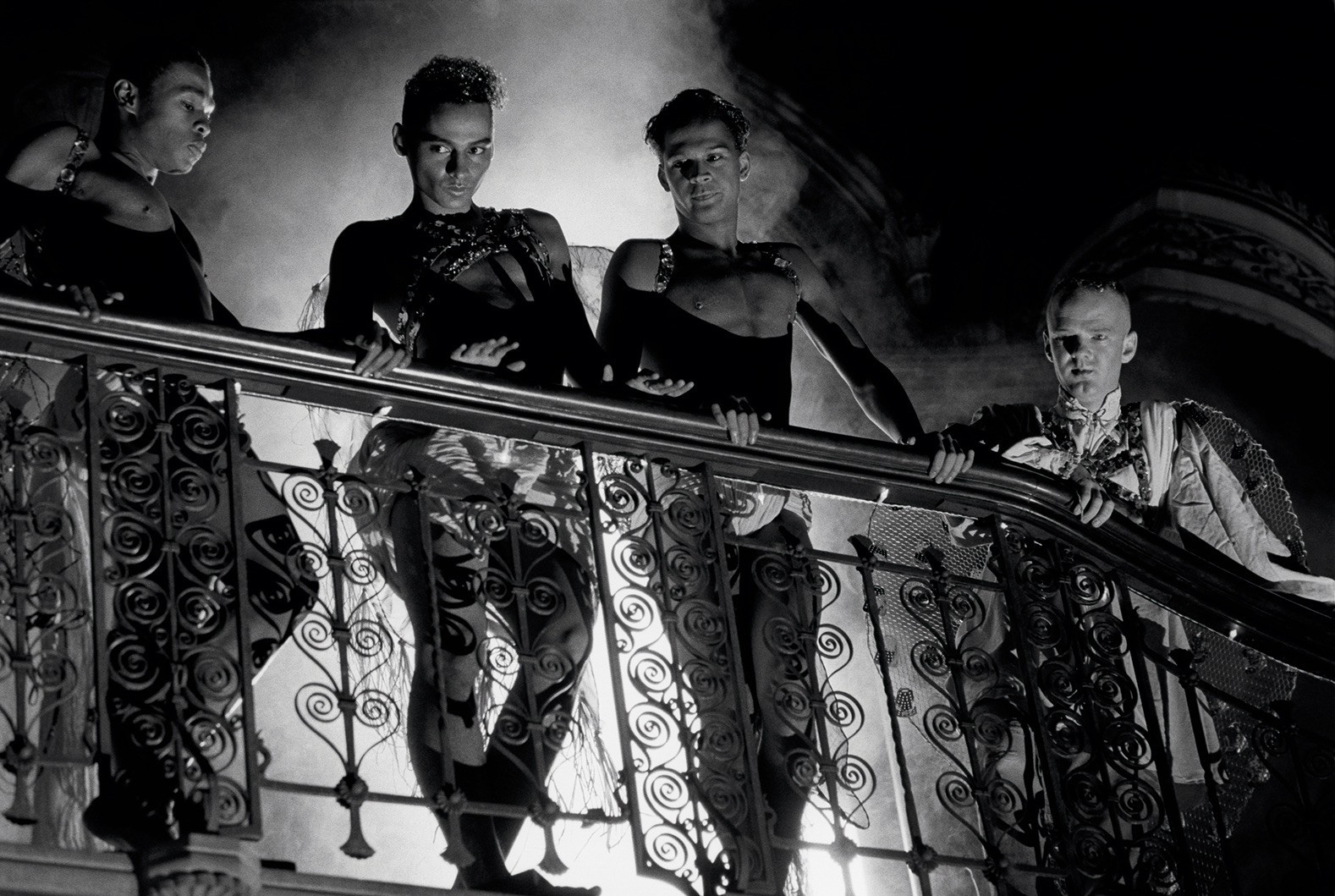 Black and white still image from the film Looking For Langston. Four men look out over a railing. 