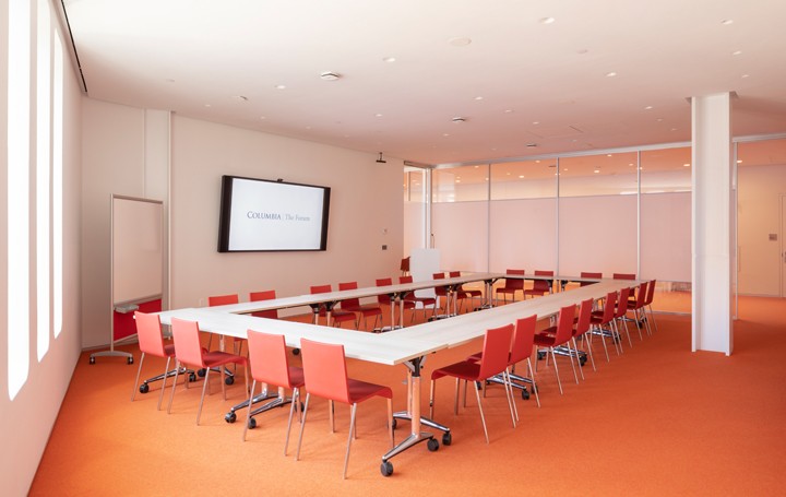 Meeting room with tables and chairs setup in a hollow square formation