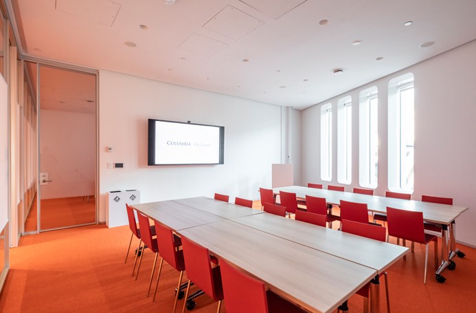 Meeting room with two groups of tables and chairs in a workshop style setup