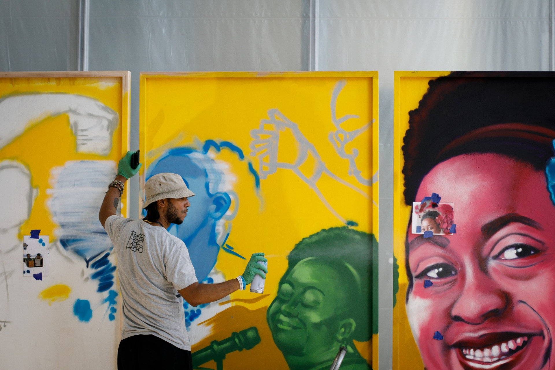 Artist Dister Rondon spray paints a large mural