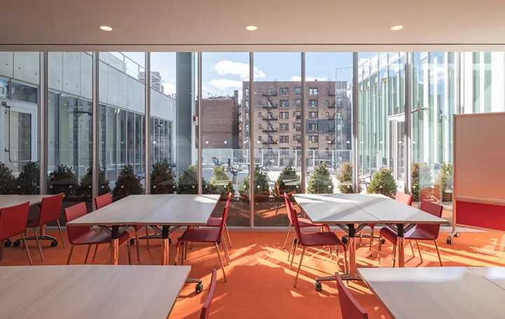 Meeting room 301 with four tables setup workshop style with view of terrace through the windows