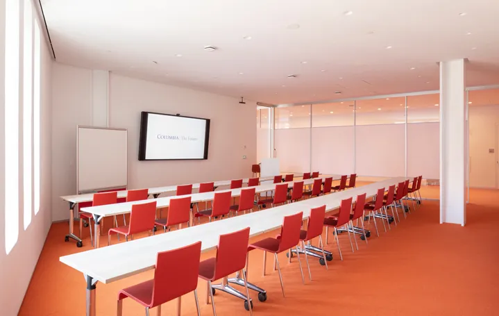 Room 315 Classroom Style setup with three rows of tables and chairs facing the podium and monitor