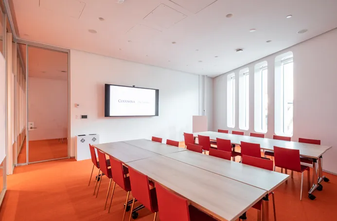 The Forum room 316 in a workshop-style setup with two rectangular tables with ten chairs at each